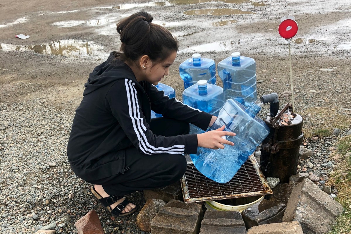 PassamaquoddyWater1 Young woman filling water jugs from clean drinking water well