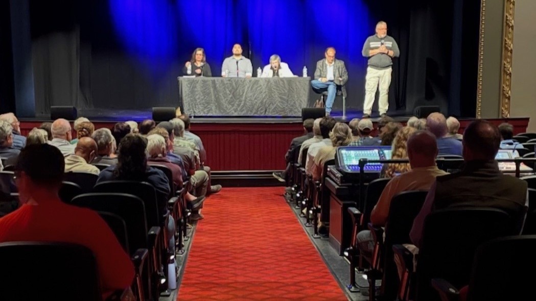 photo of an auditorium with four panelists sitting behind a table on a stage and an audience for a discussion on From Treaties to Today.