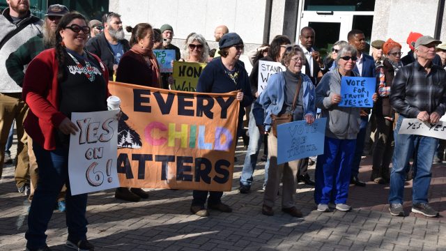 Photo: Anne Henshaw photo of crowd holding signs with text every child matters, yes on 6, vote for truth